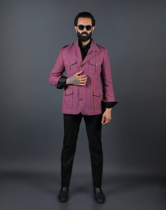 Man wearing a pink striped jacket and black pants on a gray background