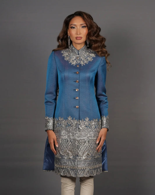 Woman wearing a blue and silver embroidered traditional outfit