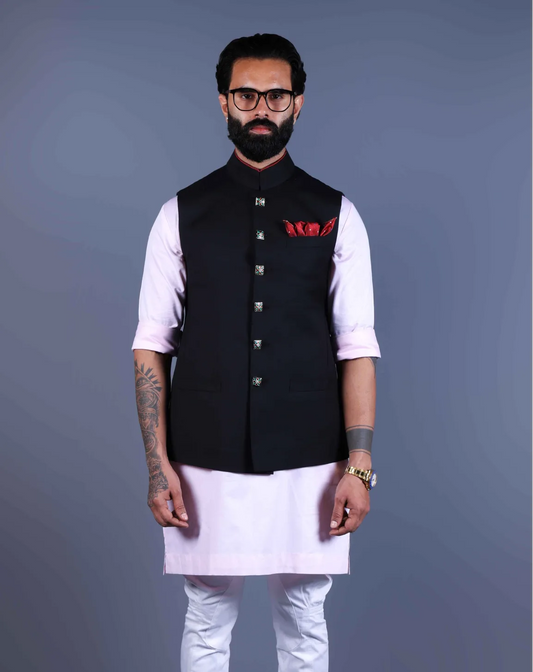 Man wearing a black Nehru Jacket with  baby pink kurta and white pajama.