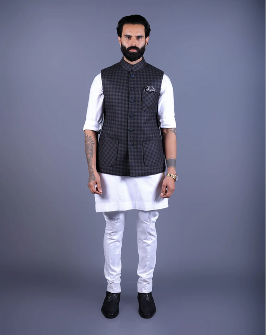 Front view of a man wearing a dark checkered Nehru jacket over a white kurta.