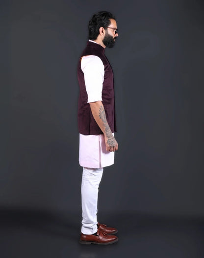 Model wearing a wine velvet nehru jacket over a baby pink kurta with white pants